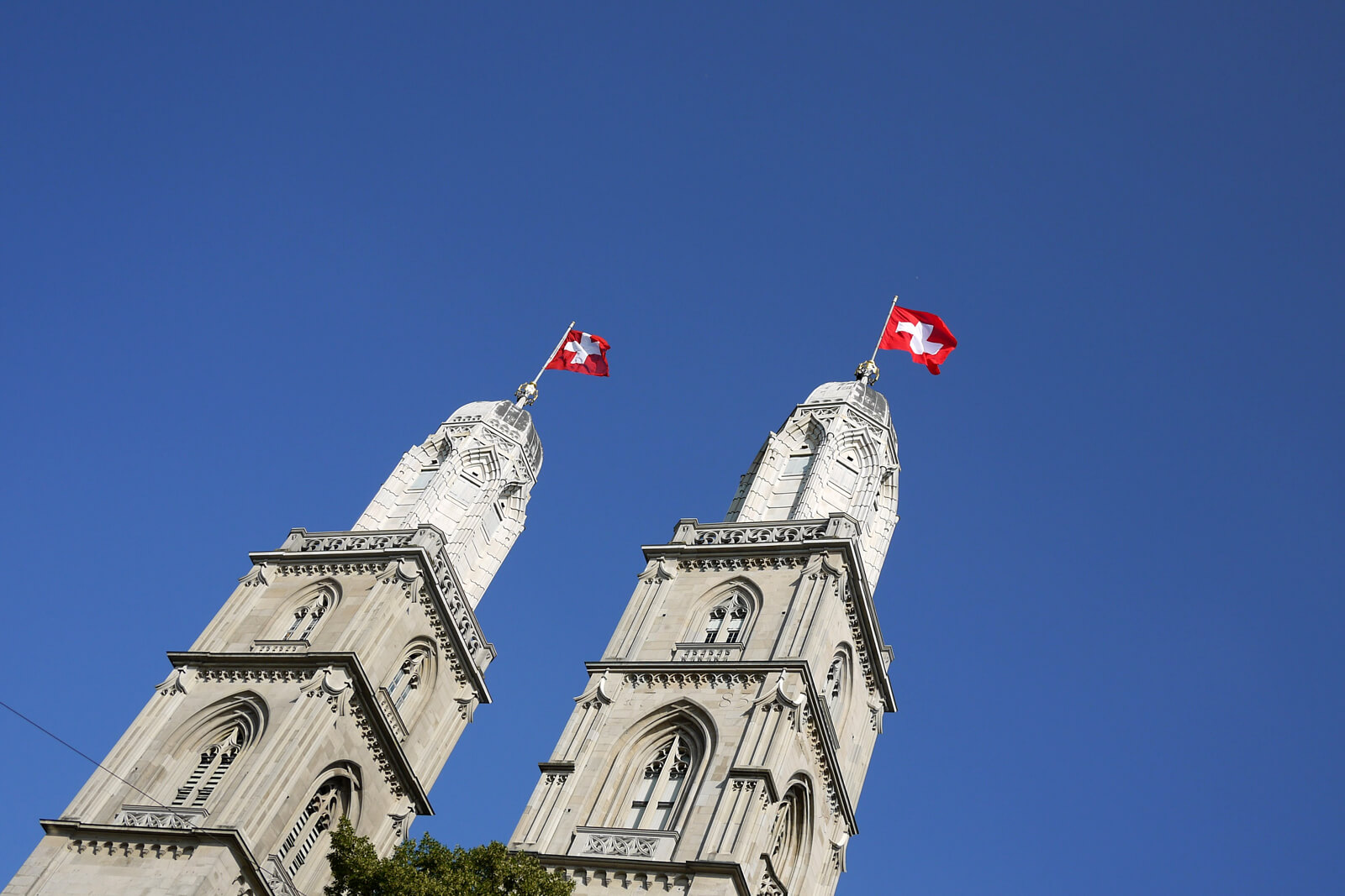 Grossmünster Towers in Zürich adorned with Swiss Flags