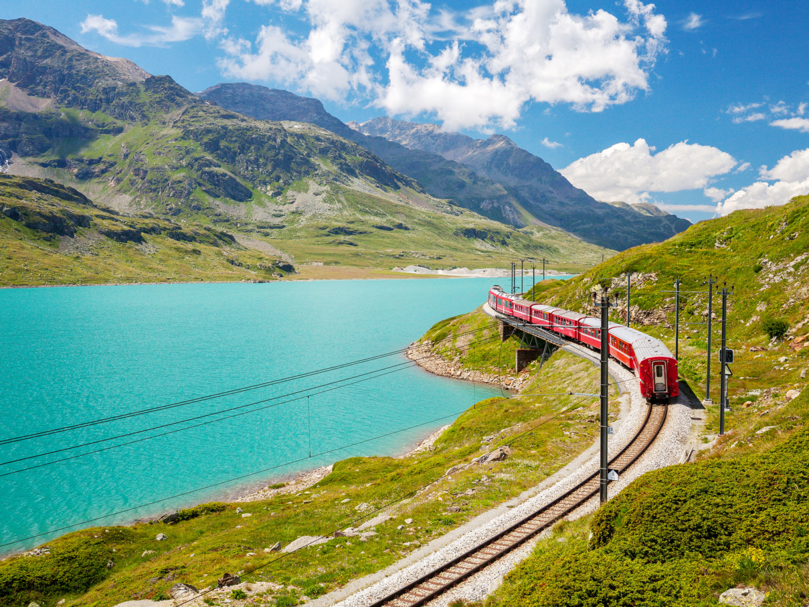 Sustainable Travel in Switzerland - Rhaetian Railways Bernina Express at Lago Bianco showing eco-friendly travel in Switzerland powered by hydroelectric power